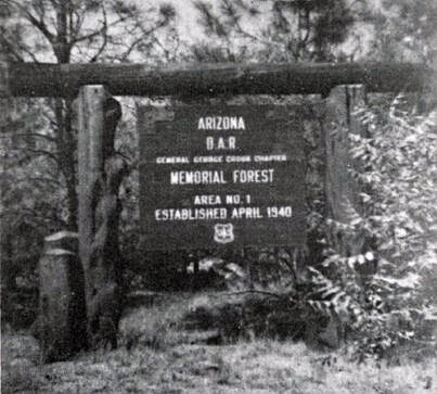 A vintage snapshot of a U.S. Forest Service sign in an outdoor setting that reads, “Arizona D.A.R. General George Crook Chapter / Memorial Forest Area No. 1 Established April 1940 [Forest Service logo]”