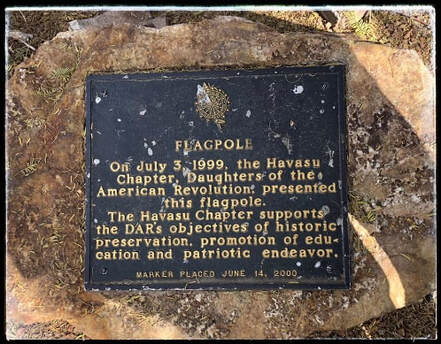 A snapshot of a marker that reads, “Flagpole / On July 3, 1999, the Havasu Chapter, DAR, presented this flagpole. / The Havasu Chapter supports the DAR’s objectives of historic preservation, promotion of education and patriotic endeavor. Marker placed June 14, 2000.”