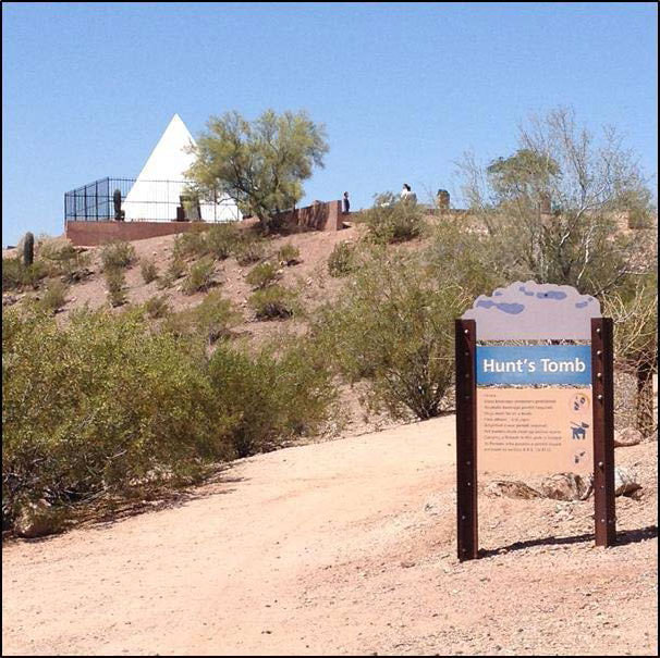 A snapshot of the desert walkway leading to the tomb, including interpretive signage. Text is unreadable.