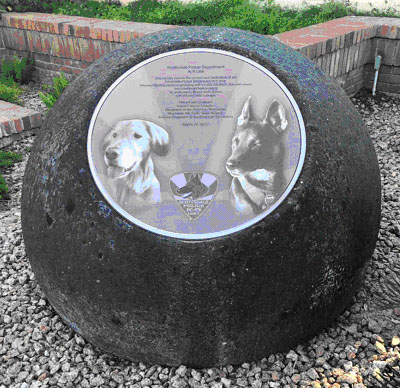 A spherical stone about three feet in diameter with a circular plaque. Text is not distinguishable.