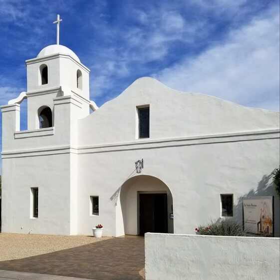 A photograph of a white church building in the Southwest style.